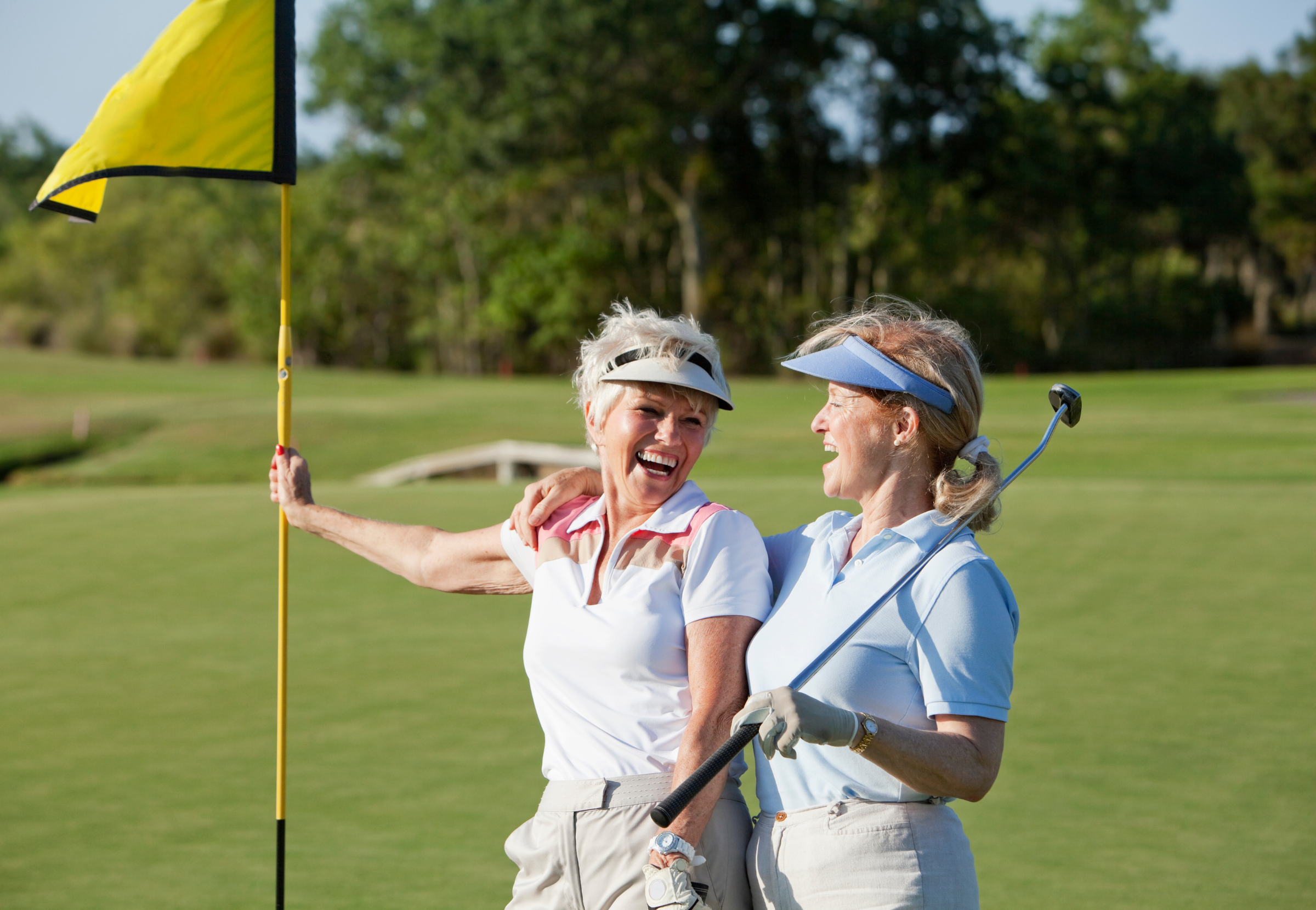 Elderly women smiling on a golf course.